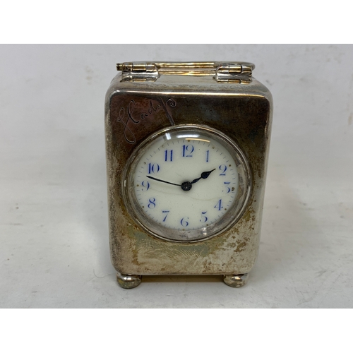 41 - An Edward VII travelling clock, the 3.5 cm dial with Arabic numerals, in a silver case, inscribed Gl... 