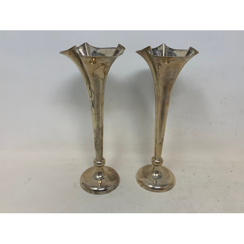 51 - A pair of silver spill vases, Birmingham 1902, loaded, 17 cm high, four small silver trophy cups, a ... 