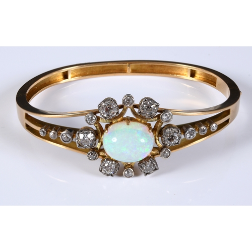 208 - A late Victorian/Edwardian yellow coloured metal bangle, set an opal within a surround of diamonds, ... 