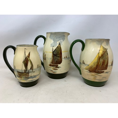 347 - A graduated set of three Royal Doulton jugs, decorated fishing boats, some crazing, the largest 20 c... 