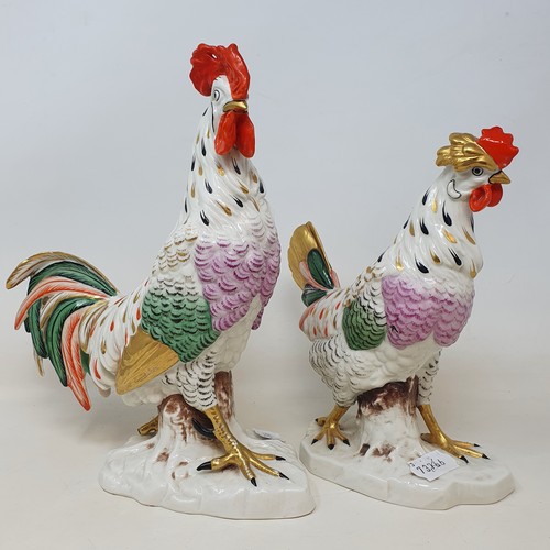 604 - A Continental porcelain model of a cockerel, 28 cm high, and a matching chicken, 22 cm high (2)