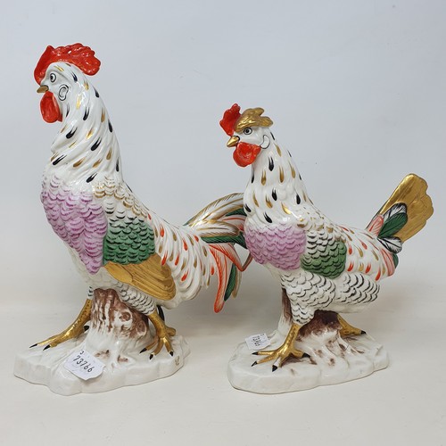 604 - A Continental porcelain model of a cockerel, 28 cm high, and a matching chicken, 22 cm high (2)