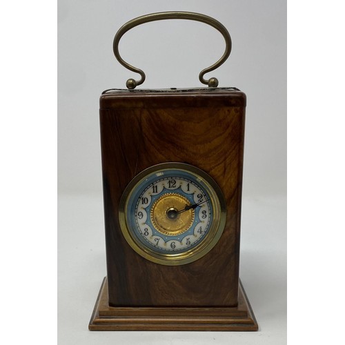 231 - A carriage timepiece, the 4.5 cm diameter dial with Arabic numerals, in a walnut case, 17 cm high