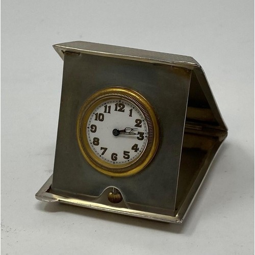 248 - A travelling timepiece, the 2.5 cm diameter enamel dial with Arabic numerals in a silver case, with ... 