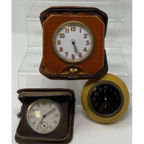 252 - A small cartel type timepiece, 7.5 cm diameter, and two travelling timepieces (3)