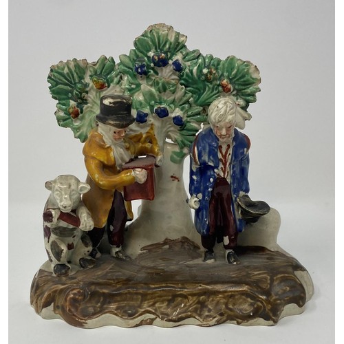 569 - An early 19th century Staffordshire group, of two men and a dancing bear, 16 cm high