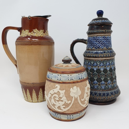 504 - A Doulton Lambeth jug and cover, decorated foliate forms, 26 cm high, a tobacco jar, 16 cm high and ...