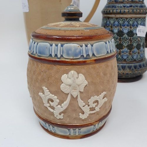 504 - A Doulton Lambeth jug and cover, decorated foliate forms, 26 cm high, a tobacco jar, 16 cm high and ...