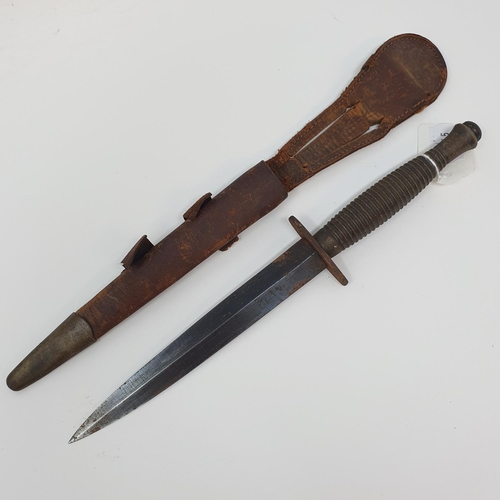 13 - A Fairbairn & Sykes type Commando fighting knife, with a ribbed handle, and a leather scabbard
Prove... 