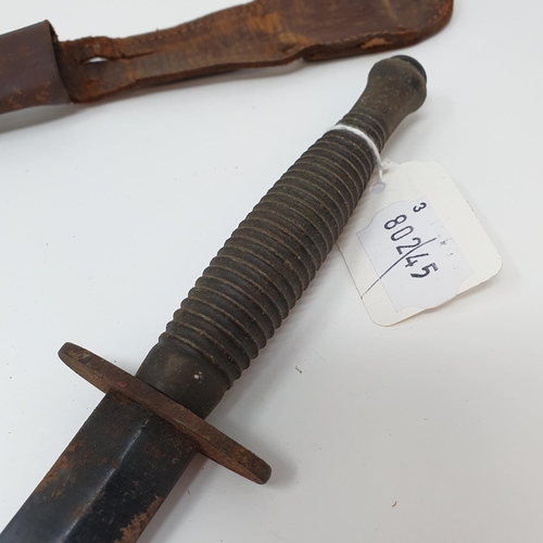 13 - A Fairbairn & Sykes type Commando fighting knife, with a ribbed handle, and a leather scabbard
Prove...