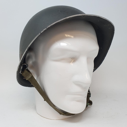 4 - An American military helmet, on a head stand...