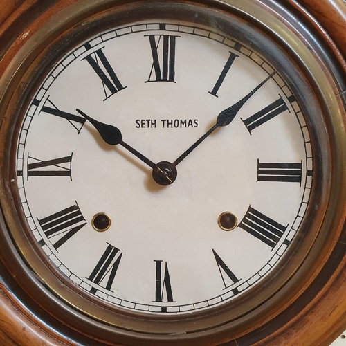 185 - A wall clock, the 18 cm diameter paper dial signed Seth Thomas, fitted a 30 hour movement, in a beec... 