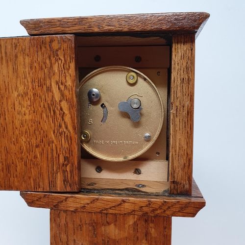 197 - A timepiece, the 4.5 cm square dial in an oak case, in the form of a longcase clock, 29.5 cm high