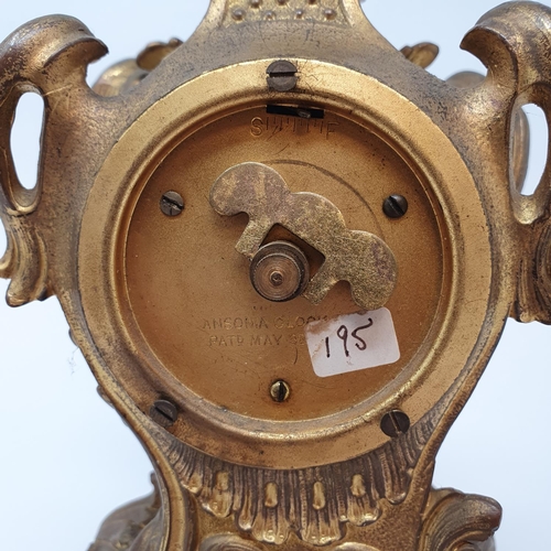 199 - A timepiece, the 5 cm diameter dial signed Ansonia, with Arabic numerals, in a gilt brass rococo sty... 