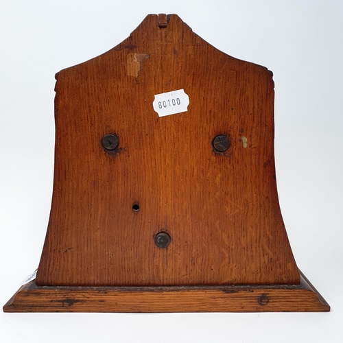 207 - An early 20th century barometer and thermometer, in an oak case carved two guns and two pickelhaubes... 