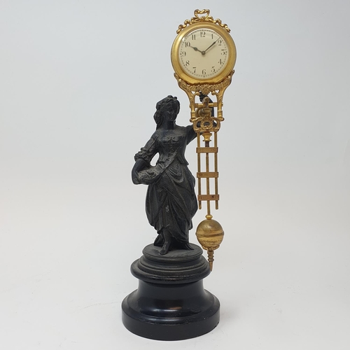 217 - An early 20th century mystery clock, mounted on a spelter figure, on a wooden base, 30 cm high (over... 