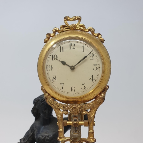 217 - An early 20th century mystery clock, mounted on a spelter figure, on a wooden base, 30 cm high (over... 