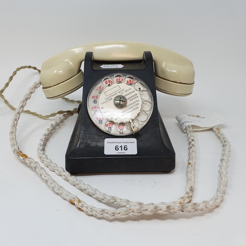 616 - A Bakelite dial telephone, with a white handle