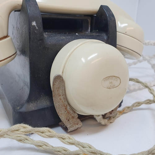 616 - A Bakelite dial telephone, with a white handle
