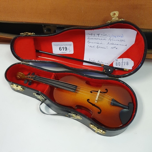 619 - A Chinese violin, with a two piece back, three bows, in case and a miniature violin and bow, in a ca... 