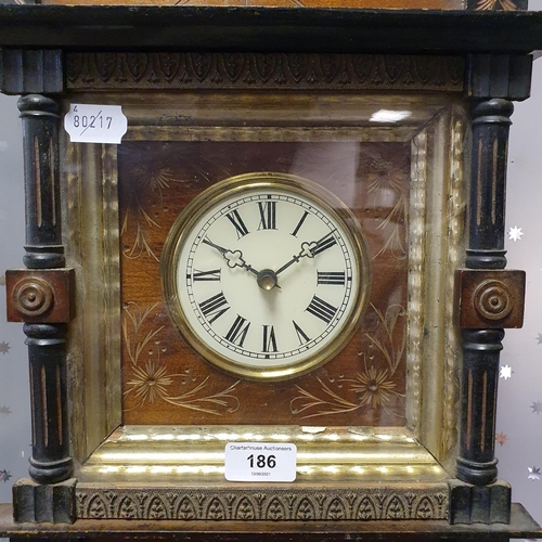 186 - A wall clock, the 10 cm diameter dial with Roman numerals, in a walnut and ebonised case, 65 cm high