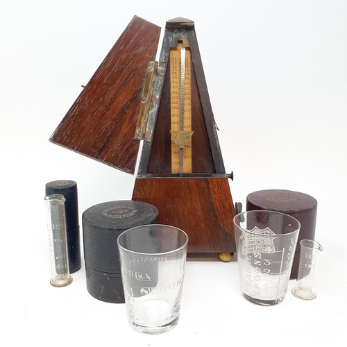 601 - An early 20th century metronome, in a rosewood case, nine glass measures in leather cases and other ... 