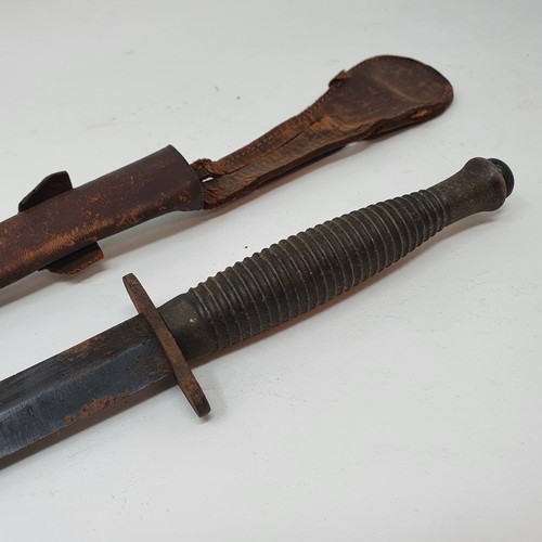 13 - A Fairbairn & Sykes type Commando fighting knife, with a ribbed handle, and a leather scabbard
Prove... 