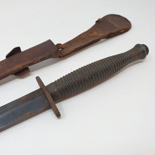 13 - A Fairbairn & Sykes type Commando fighting knife, with a ribbed handle, and a leather scabbard
Prove...