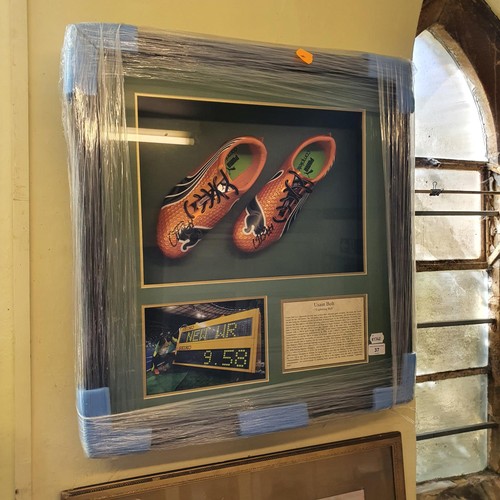 37 - A pair of Puma complete orange shoes, signed by Usain Bolt, the box frame 66 cm high x 62 wide...