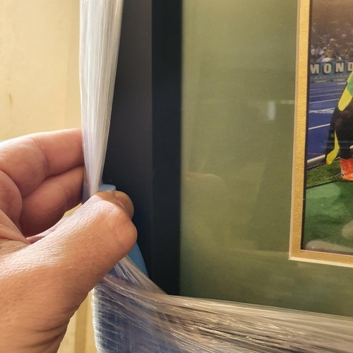 37 - A pair of Puma complete orange shoes, signed by Usain Bolt, the box frame 66 cm high x 62 wide...