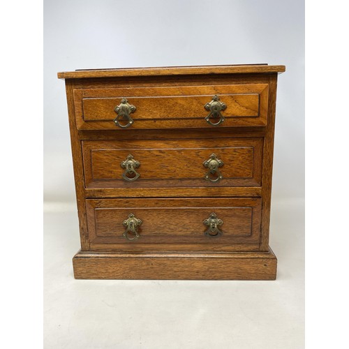 486 - An early 20th century mahogany miniature chest, having three drawers, 30 cm high x 28 cm wide, an ab... 