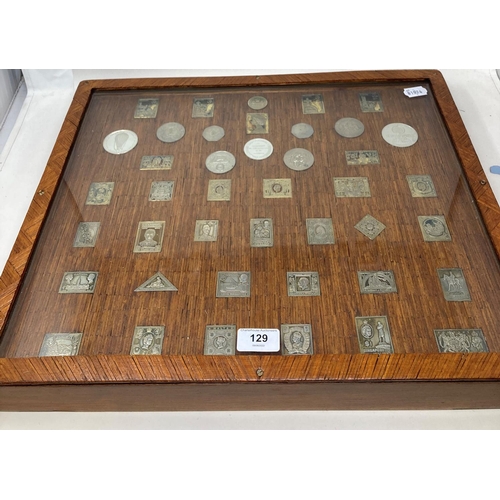 129 - A set of silver postage stamp coin medallions, and other medallions, set in a frame constructed from... 