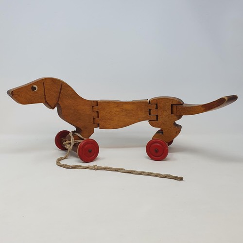 208 - A 1950's wooden toy boat by Kellner, and a treen pull along dog (2)