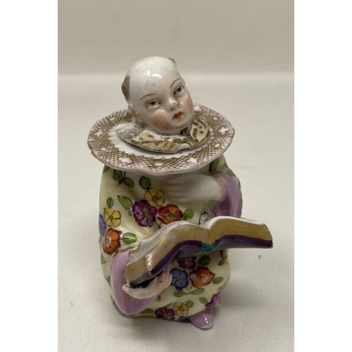 503A - A 19th century Dresden novelty bottle, of a young boy reading a book, 9 cm high