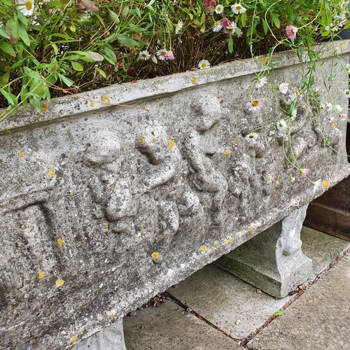 14 - A reconstituted stone garden planter, decorated figures, 86 cm wide, on a stand...