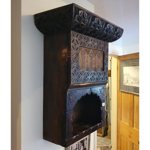 173 - An early 20th century carved and painted wall cabinet, having a panel door above a recess, 56 cm wid... 