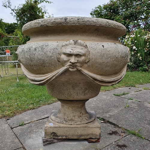18 - A Coade style garden urn, decorated face masks and swags, some frost damage and a few chips, approx....