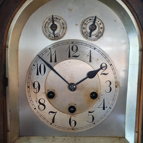 183 - An Edwardian oak mantel clock, the 15 cm arched square silvered dial with Arabic numerals and Chime/... 