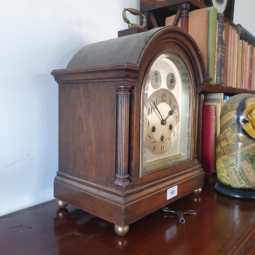 183 - An Edwardian oak mantel clock, the 15 cm arched square silvered dial with Arabic numerals and Chime/... 