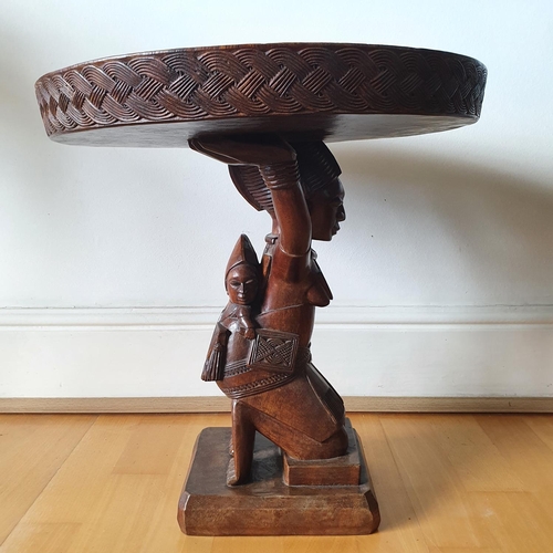 221 - An African low table, on a carved figural support, 45 cm high