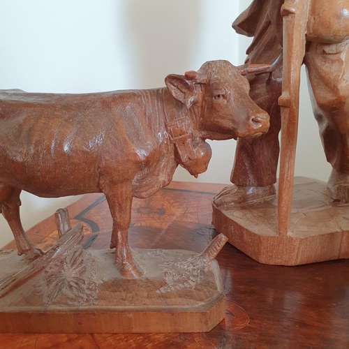 231 - A pair of Austrian style carved wood figures of cattle, approx. 17 cm high and a similar carved figu... 