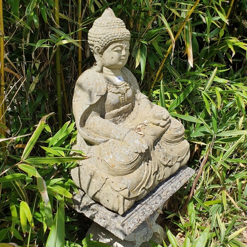 63 - A reconstituted stone figure, of a seated buddha, on a stand, approx. 98 cm high