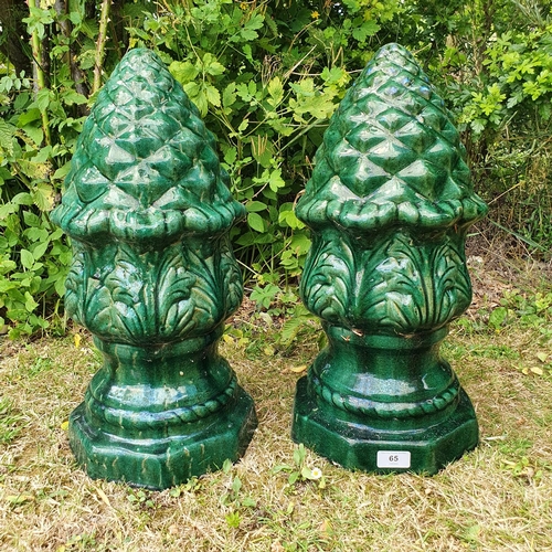 65 - A pair of green glazed pineapple type finials, 48 cm high, and the group of planters on the gravel i... 