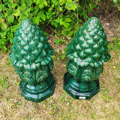 65 - A pair of green glazed pineapple type finials, 48 cm high, and the group of planters on the gravel i... 