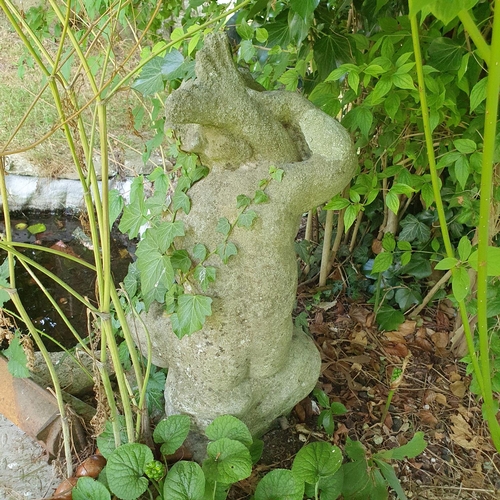 69 - A reconstituted stone garden fountain, in the form of a child holding a dolphin, approx. 65 cm high