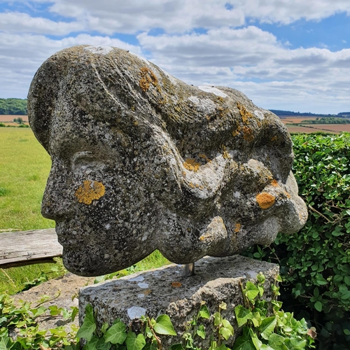 73 - A carved stone garden ornament, in the form of a lady's head, with her hair flowing behind, approx. ... 