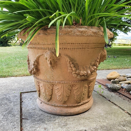 91 - A pair of garden urns, decorated facemasks and foliage, approx. 49 cm high, and another plain pot, a... 