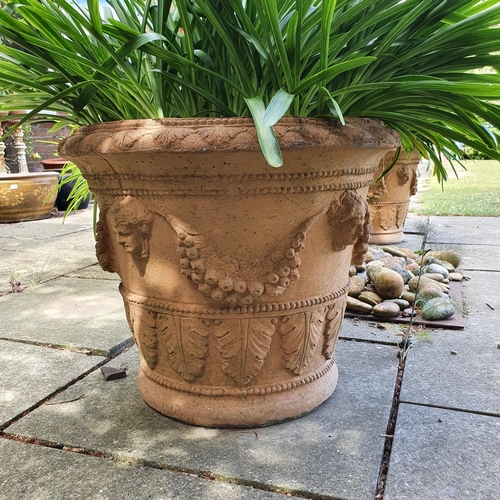 91 - A pair of garden urns, decorated facemasks and foliage, approx. 49 cm high, and another plain pot, a... 