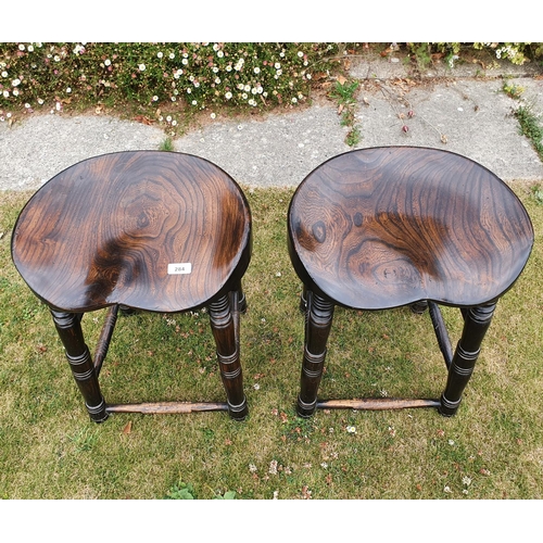 284 - A pair of elm bum stools, on turned legs, 52 cm high (2)