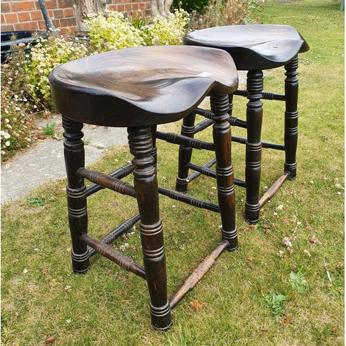 284 - A pair of elm bum stools, on turned legs, 52 cm high (2)